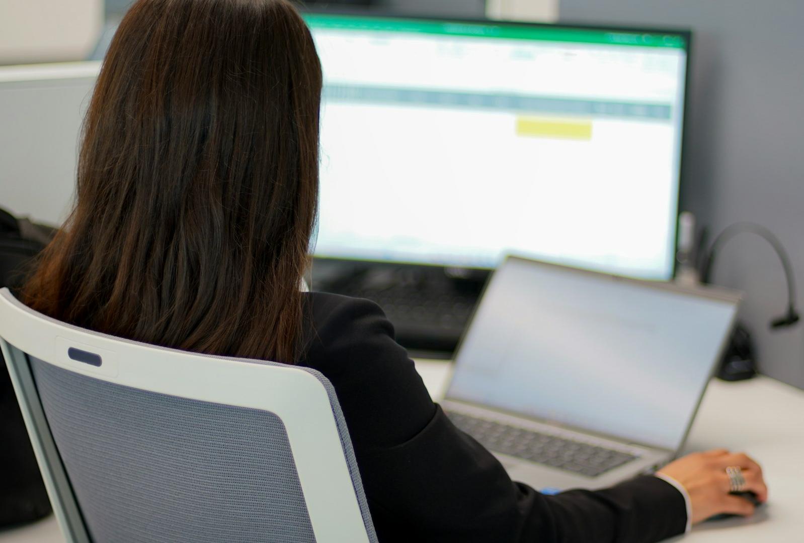 a woman sitting in front of a laptop computer